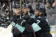 Seattle Kraken defenseman Mark Giordano, center, celebrates with right wing Jordan Eberle (7) and left wing Jared McCann after Giordano scored a goal against the Vancouver Canucks during the third period of an NHL hockey game Saturday, Oct. 23, 2021, in Seattle. (AP Photo/Ted S. Warren)