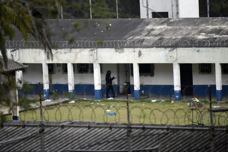 A policeman patrols outside the Stage II Male Juvenile Detention Center in San Jose Pinula, before an operation to rescue four hostages held by inmates inside the prison on March 20, 2017