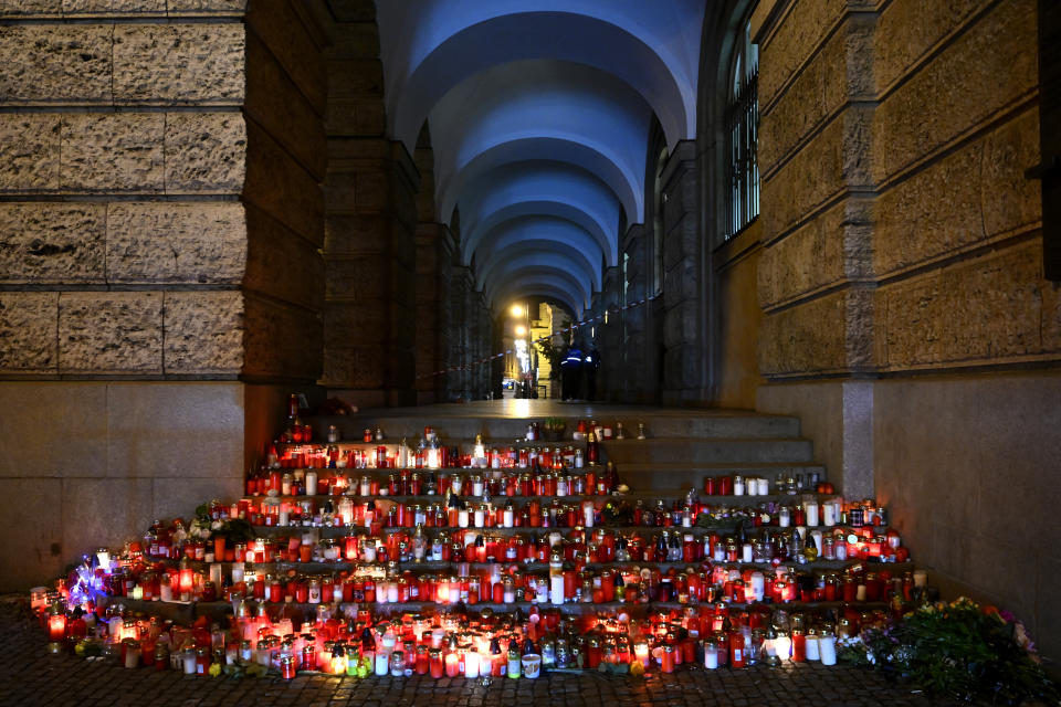 Flowers and candles are placed outside the building of Philosophical Faculty of Charles University in downtown Prague, Czech Republic, Saturday, Dec. 23, 2023. A lone gunman opened fire at a university on Thursday, killing more than a dozen people and injuring dozens. (AP Photo/Denes Erdos)