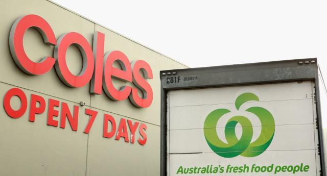 Woolworths truck in front of Coles supermarket sign