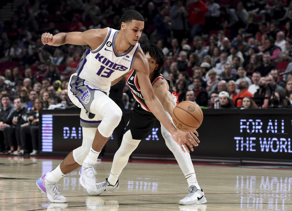 Sacramento Kings forward Keegan Murray, left and Portland Trail Blazers guard Shaedon Sharpe, right, go after a ball during the first half of an NBA basketball game in Portland, Ore., Friday, March 31, 2023. (AP Photo/Steve Dykes)