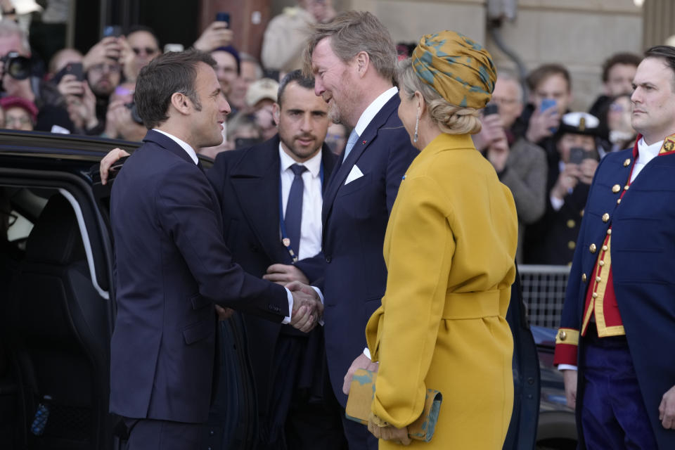 French President Emmanuel Macron, left, is welcome by Dutch King Willem-Alexander and Queen Maxima outside the royal palace on Dam square in Amsterdam, Netherlands, Tuesday, April 11, 2023. French President Emmanuel Macron begins a two-day state visit to the Netherlands on Tuesday and is making a speech on his vision for the future of Europe. (AP Photo/Peter Dejong)