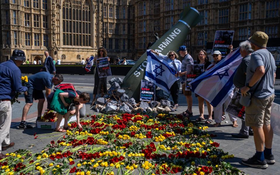 Pro-Israeli demonstrators stage a counter-protest around an Oxfam mock bomb used to protest against Britain's supply of weapons to Israel