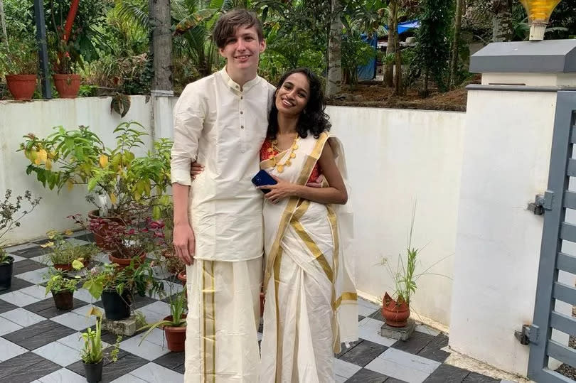 Jay and Veena standing together dressed in traditional wedding party attire.