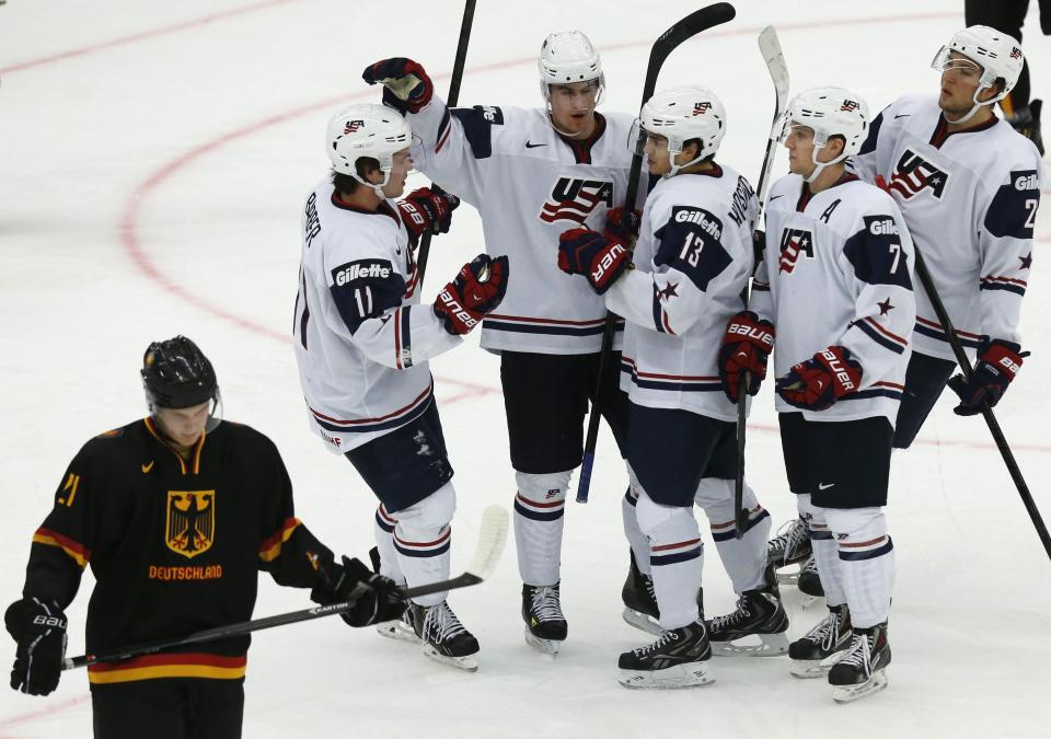 U.S. team players celebrate scoring past Germany's Dominik Kahun (L) during the first period of their IIHF World Junior Championship ice hockey game in Malmo, Sweden, December 29, 2013. REUTERS/Alexander Demianchuk (SWEDEN - Tags: SPORT ICE HOCKEY)