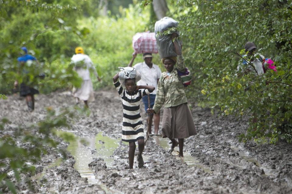 Villagers carry food for people taking care of their livestock in Tsholostho, about 200 kilometers north of Bulawayo, Saturday, March 4, 2017. Zimbabwe says floods have killed over 200 people and left close to 2,000 homeless since December. The Southern African country has appealed to International donors for $100 million to help those affected by floods. (AP Photo/Tsvangirayi Mukwazhi)