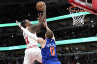 Chicago Bulls forward DeMar DeRozan, left, drives to the basket against New York Knicks guard Donte DiVincenzo during the second half of an NBA basketball game in Chicago, Tuesday, April 9, 2024. (AP Photo/Nam Y. Huh)