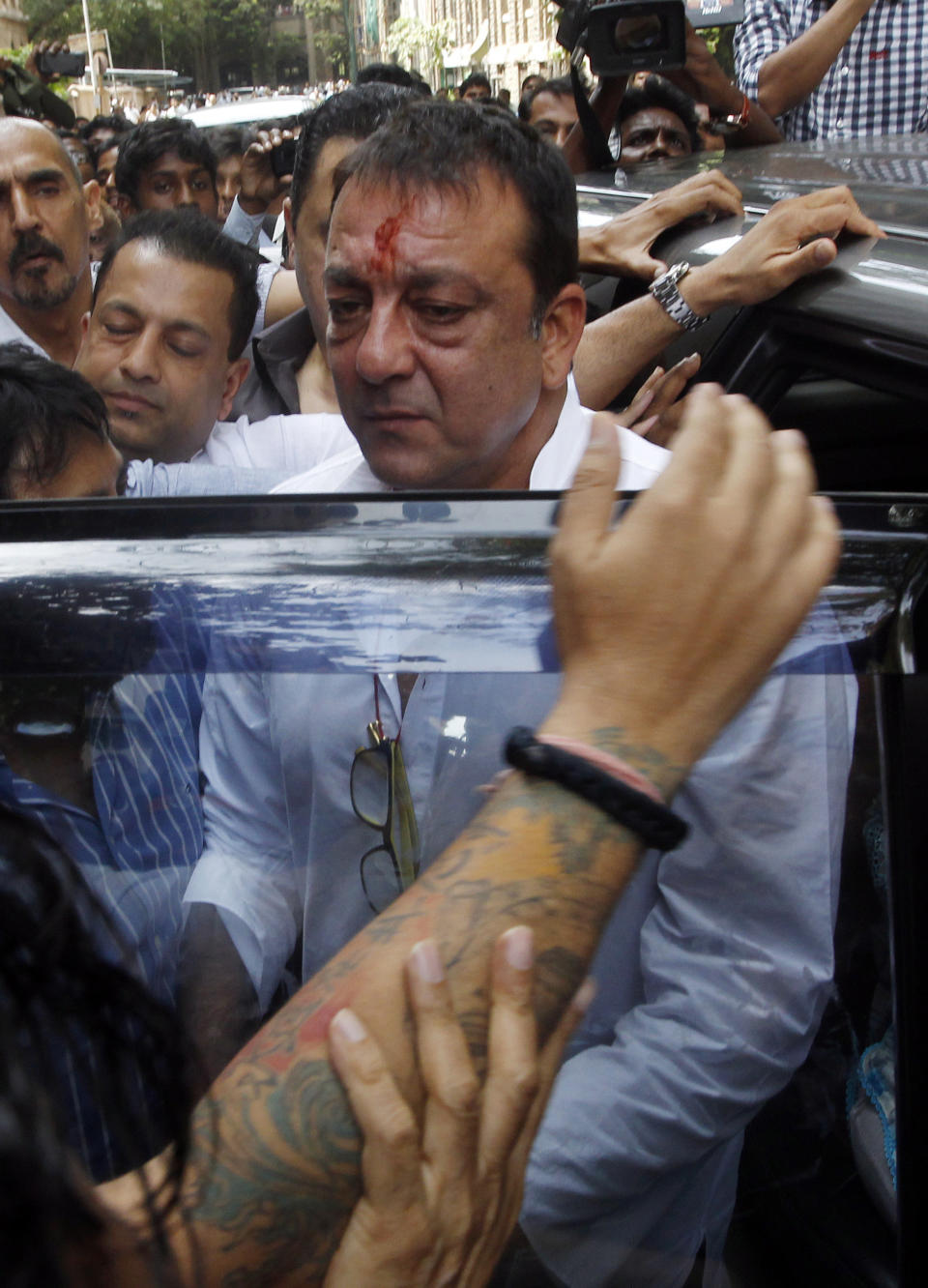 Bollywood star Sanjay Dutt, center, arrives to surrender before a court in Mumbai, India, Thursday, May 16, 2013. Dutt has been sentenced to five years in prison for a 1993 weapons conviction linked to a deadly terror attack in Mumbai that killed 257 people. The 53-year-old actor served 18 months in jail before being released on bail in 2007 pending an appeal. The Supreme Court reduced his prison sentence to five years from the six-year term initially handed down. (AP Photo/Rajanish Kakade)