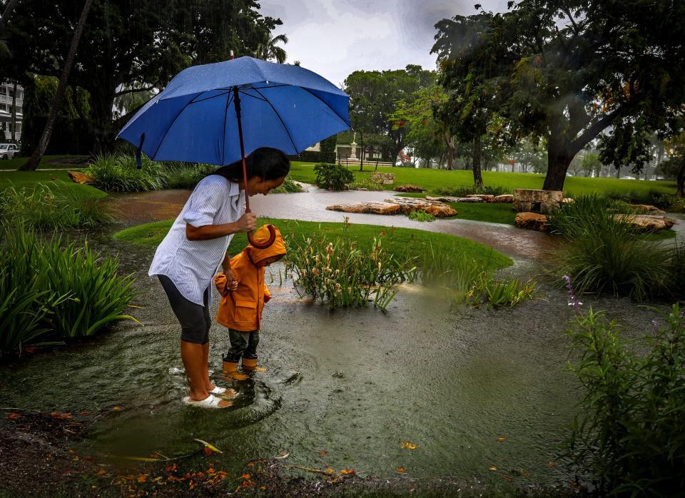 Wingate Frisbie, 2, and his nanny Jennifer Tsugranes have some fun on a wet, dreary day by sloshing through water that has settled in the Tidal Garden at Bradley Park Saturday June 4, 2022. Heavy rainfall and possible flooding is expected throughout the day.