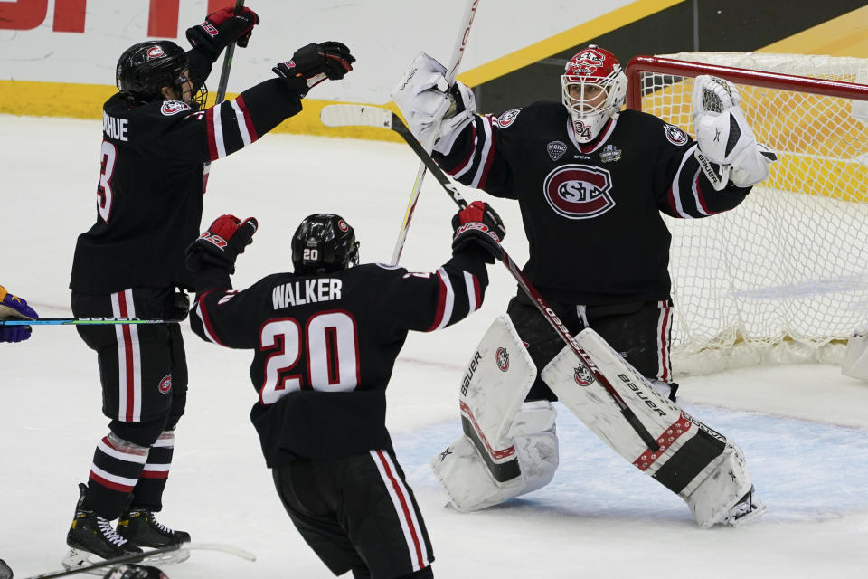 St. Cloud State goaltender David Hrenak, right, celebrates with Nolan Walker (20) and Seamus Donohue after the team's 5-4 wi over Minnesota State in an NCAA men's Frozen Four hockey semifinal in Pittsburgh, Thursday, April 8, 2021. (AP Photo/Keith Srakocic)