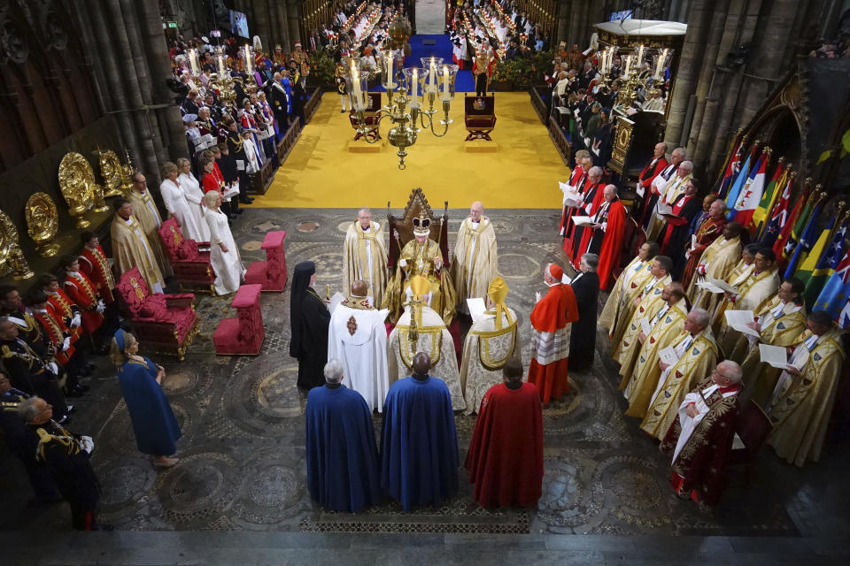 FILE - Britain's King Charles III sits after being crowned with St Edward's Crown by The Archbishop of Canterbury Justin Welby during his coronation ceremony in Westminster Abbey, London, Saturday, May 6, 2023. King Charles III’s decision to be open about his cancer diagnosis has helped the new monarch connect with the people of Britain and strengthened the monarchy in the year since his dazzling coronation at Westminster Abbey. (Aaron Chown/Pool Photo via AP, File)