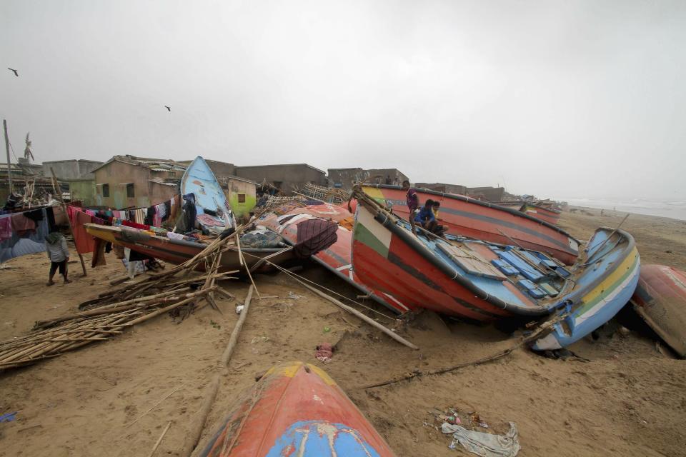 Children sit on a boat damaged by Cyclone Fani in the Penthakata fishing village of Puri, in the eastern Indian state of Orissa, Saturday, May 4, 2019. A mammoth preparation exercise that included the evacuation of more than 1 million people appears to have spared India a devastating death toll from one of the biggest storms in decades, though the full extent of the damage was yet to be known, officials said Saturday. (AP Photo)