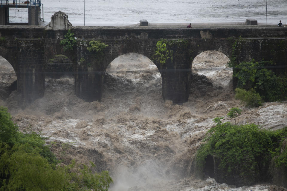 The swollen Los Esclavos River flows violently under a bridge during tropical storm Amanda in Cuilapa, eastern Guatemala, Sunday, May 31, 2020. The first tropical storm of the Eastern Pacific season drenched parts of Central America on Sunday and officials in El Salvador said at least seven people had died in the flooding. (AP Photo/Moises Castillo)