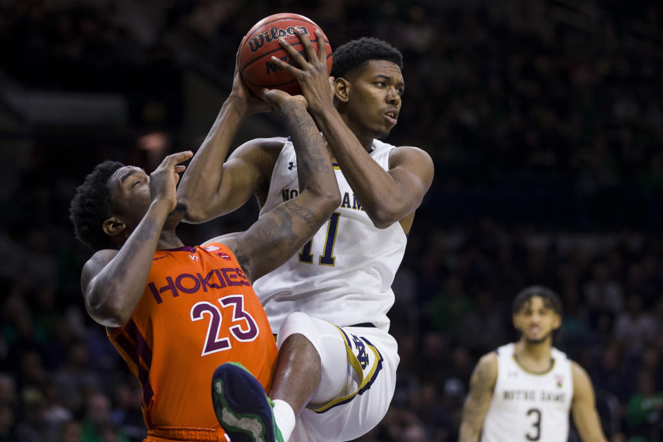 Notre Dame's Juwan Durham (11) grabs a rebound over Virginia Tech's Tyrece Radford (23) during the first half of an NCAA college basketball game Saturday, March 7, 2020, in South Bend, Ind. (AP Photo/Robert Franklin)