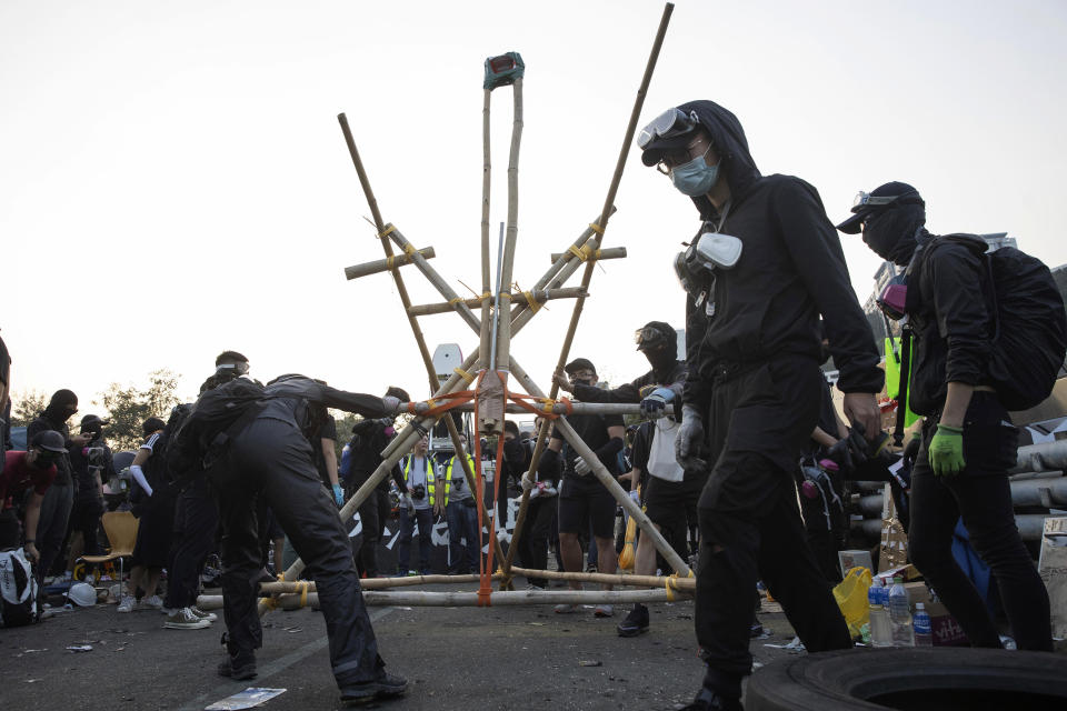 In this Wednesday, Nov. 13, 2019, file photo, protesters test a self-made catapult on the barricaded bridge which leads into the Chinese University of Hong Kong, in Hong Kong. Protesters who barricaded themselves inside Hong Kong’s universities have tried to turn the campuses into armed camps, resorting to medieval weapons to stop police from entering the grounds. Their weapons include bows and arrows, catapults and hundreds of gasoline bombs stacked up to ramparts - often built by the students. (AP Photo/Ng Han Guan, File)