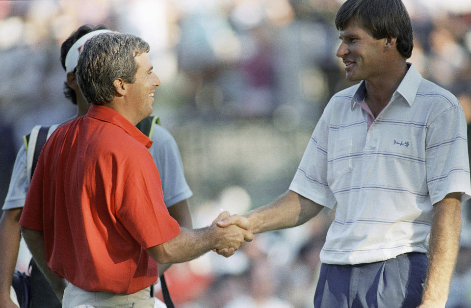 FILE - Curtis Strange, left, and Nick Faldo shake hands in Brookline, Mass., Sunday, June 19, 1988, after finishing the U.S. open with tie scores, forcing an 18-hole playoff round the following day at the Country Club in Brookline. Strange won the 18-hole playoff the next day. The U.S. Open returns to The Country Club in June 2022 for the first time since then. (AP Photo/Peter Southwick, File)