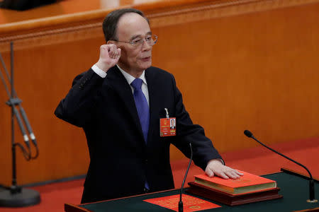 Newly elected Chinese Vice President Wang Qishan with his hand on the Constitution takes the oath at the fifth plenary session of the National People's Congress (NPC) at the Great Hall of the People in Beijing, China March 17, 2018. REUTERS/Jason Lee