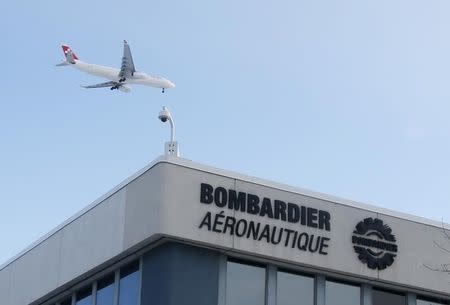 A plane flies over a Bombardier plant in Montreal, January 21, 2014. REUTERS/Christinne Muschi