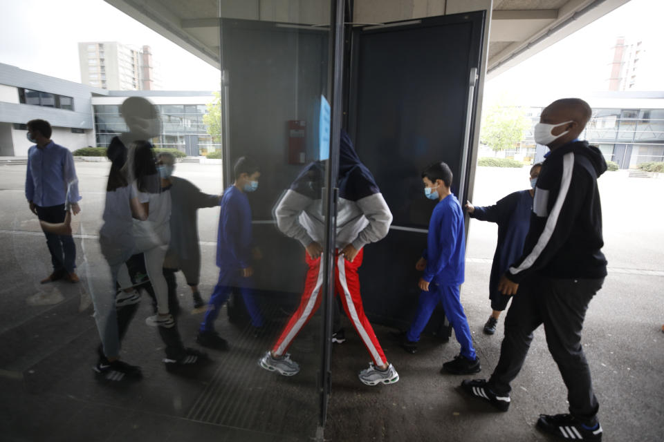 Schoolchildren walk back to school after a break in Bischheim, outside Strasbourg, eastern France, Tuesday, Sept.1, 2020. Millions of French children starting going back to class Tuesday despite a recent rise in virus infections, in a nationwide experiment aimed at bridging inequalities and reviving the economy. (AP Photo/Jean-Francois Badias)