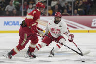 Denver forward Aidan Thompson (7) and Boston University forward Ryan Greene (9) fight for the puck during the third period of a semifinal game at the Frozen Four NCAA college hockey tournament Thursday, April 11, 2024, in St. Paul, Minn. (AP Photo/Abbie Parr)