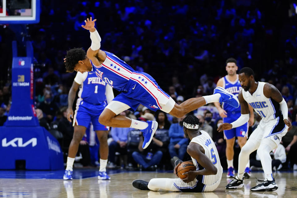 Philadelphia 76ers' Matisse Thybulle, left, goes flying after chasing after a loose ball against Orlando Magic's Mo Bamba during the first half of an NBA basketball game, Monday, Nov. 29, 2021, in Philadelphia. (AP Photo/Matt Slocum)