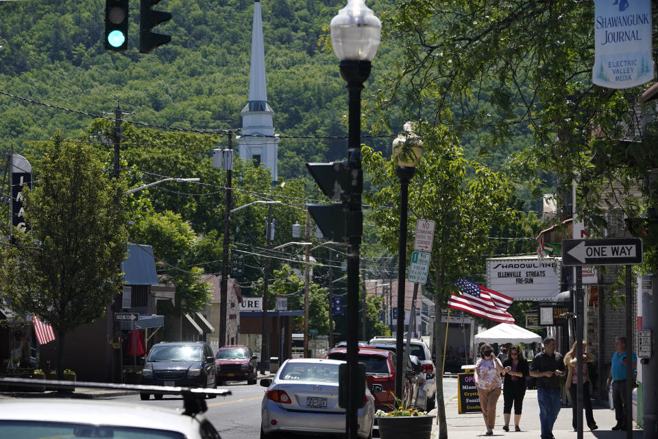 People walk on one of the main streets in Ellenville, N.Y., Wednesday, June 16, 2021. Less than 100 miles north of New York City, Ulster County is popular destination for weekenders headed to Woodstock or the Catskill Mountains. Though pretty, there are pockets of poverty. The county is working with the Center for Guaranteed Income Research at the University of Pennsylvania on a pilot program funded by private donations. One hundred households making less than $46,900 a year in May began receiving a $500 payment each month for a year. Recipients of the money can spend it as they wish, but will be asked to participate in periodic surveys about their physical health, mental health and employment status. (AP Photo/Seth Wenig)