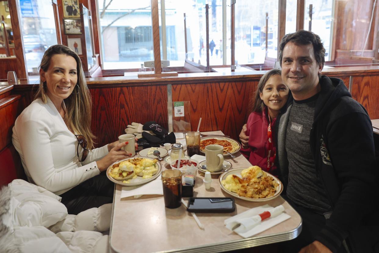 The Morales family from Orlando, Fla., poses for a portrait inside Tom's Restaurant on the first day of indoor dining in New York City on Friday, Feb. 12. 