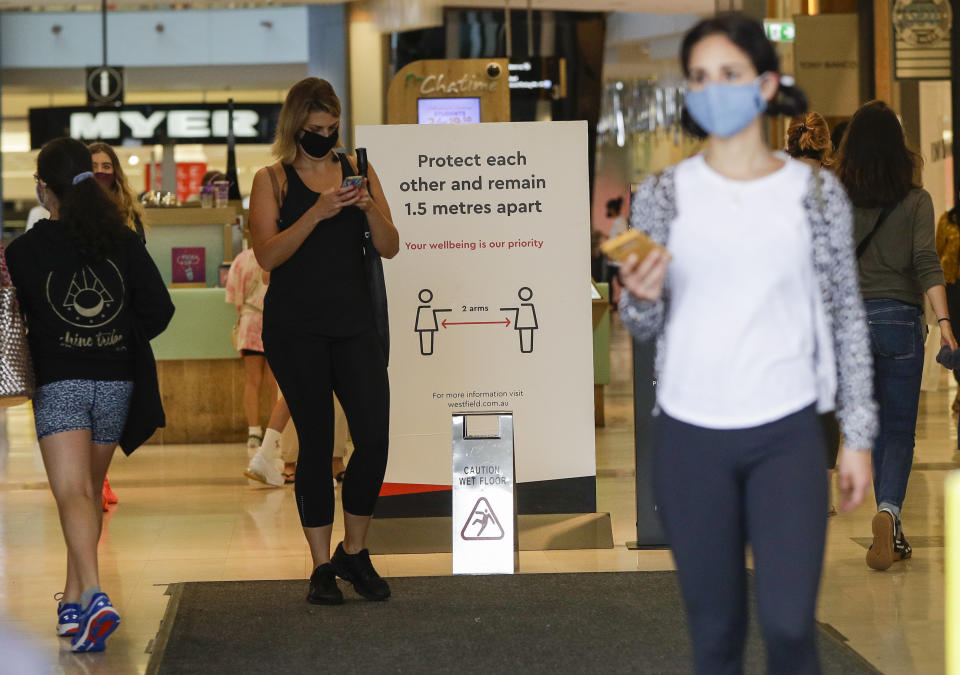 Shoppers wear masks as they walk around a shopping centre in Sydney, Australia, Sunday, Jan. 3, 2021. Masks have been made mandatory in shopping centers, on public transport, in entertainment venues such as a cinema, and fines will come into effect on Monday as the state government responds to the COVID-19 outbreak on Sydney's northern beaches, which is suspected to have also caused new cases in neighboring Victoria state. (AP Photo/Mark Baker)