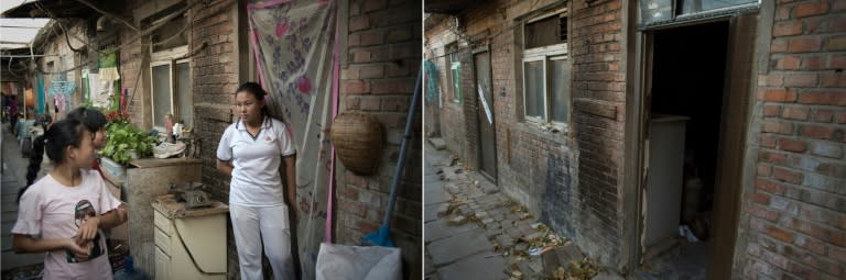 A large grease stain is left on a brick wall where a woman used to cook meals outside her home