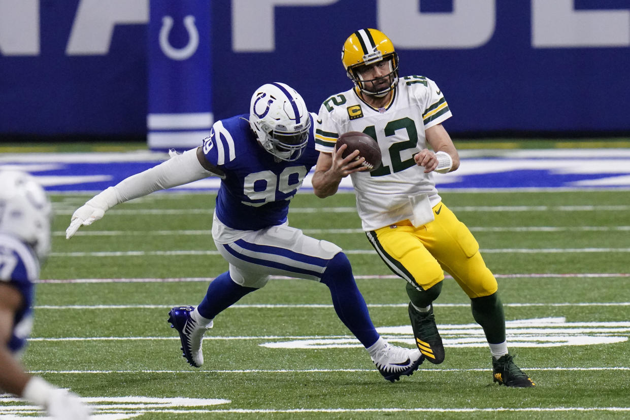 Green Bay Packers quarterback Aaron Rodgers (12) runs from Indianapolis Colts' DeForest Buckner (99) during the first half of an NFL football game, Sunday, Nov. 22, 2020, in Indianapolis. (AP Photo/AJ Mast)
