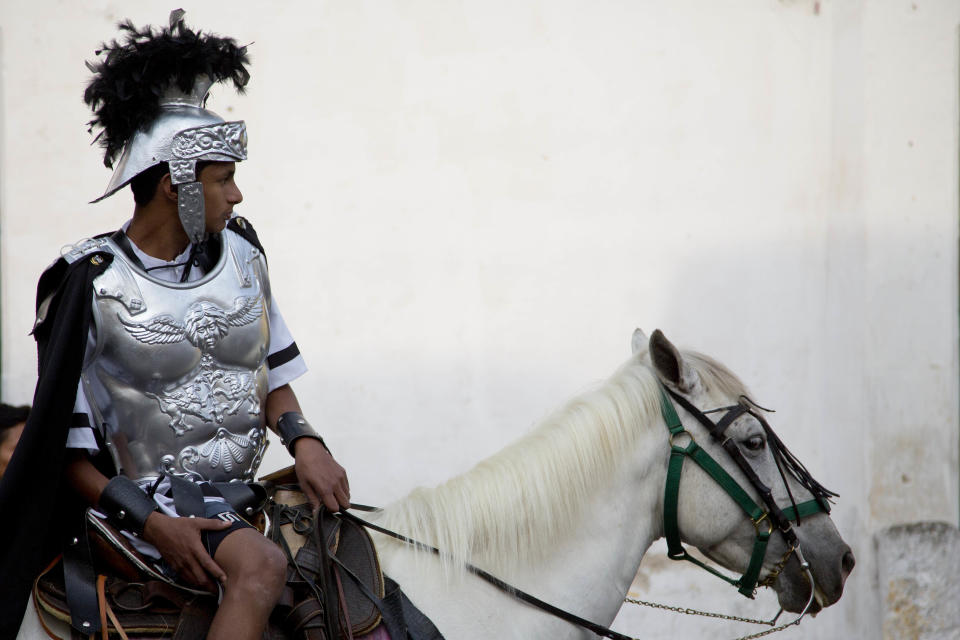 Un hombre vestido como un soldado romano cabalga durante una procesión de la Iglesia La Merced como parte de las celebraciones de semana Semana Santa en Antigua, Guatemala, el viernes 18 de abril del 2014. (Foto AP/Moisés Castillo)