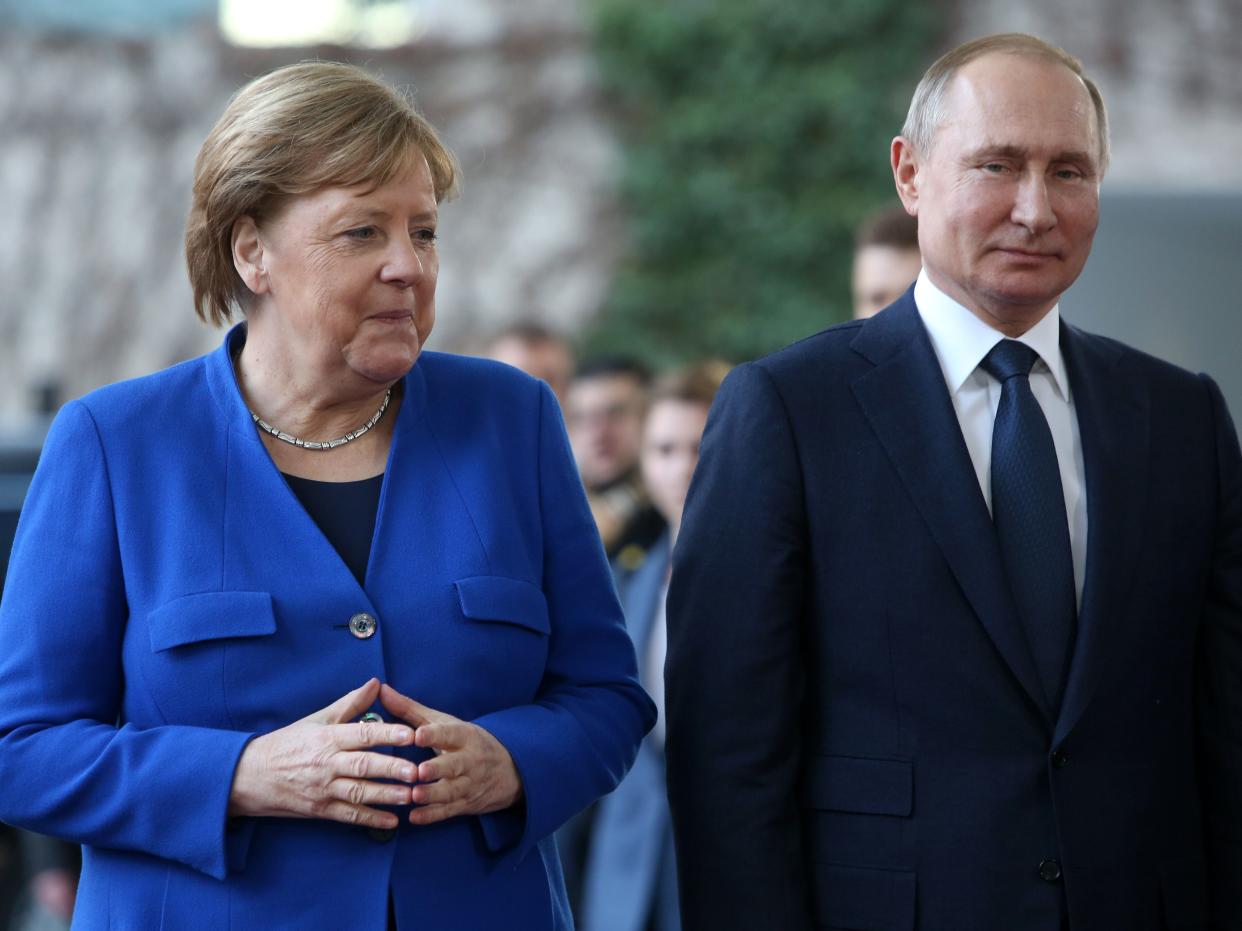 German Chancellor Angela Merkel (L) greets Russian President Vladimir Putin.