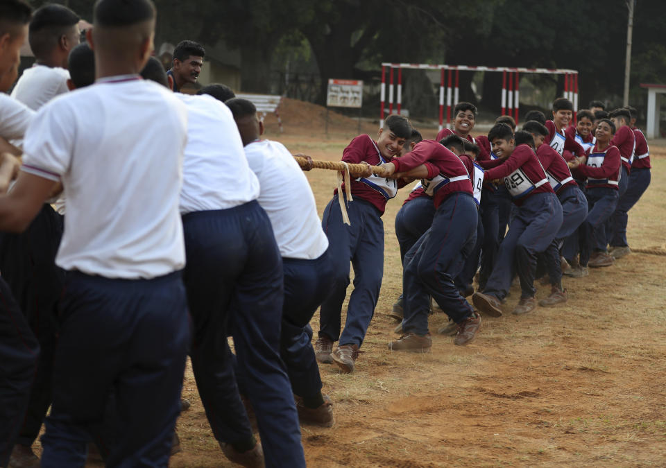 FILE - In this March 31, 2021, file photo, Indian army women recruits, right, compete with men in a tug-of-war as part of their training before they are inducted as the first women soldiers below officer rank, during a media visit in Bengaluru, India. India’s top court on Wednesday, Sept. 22 allowed young women to take the entrance examination to the country's national defense academy for the first time in November, a watershed moment for them to join the armed forces as officers. The court had rejected the government plea that women were not suitable for commanding posts in the army, saying male troops were not prepared yet to accept female officers. (AP Photo/Aijaz Rahi)