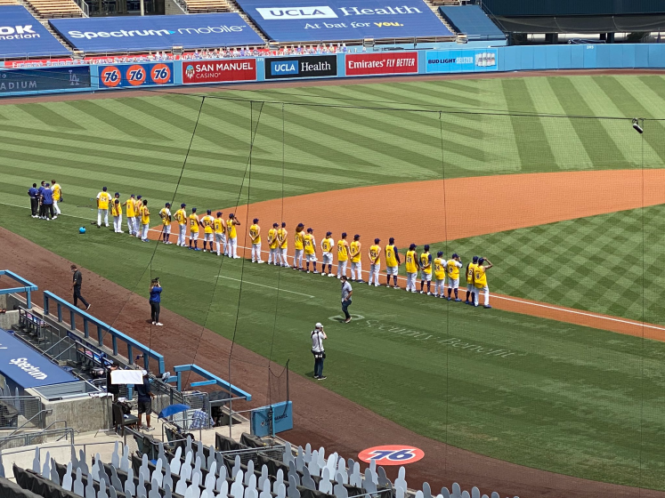 Dodgers players wear Kobe Bryant jerseys while lining up on the field before a game against the Colorado Rockies.