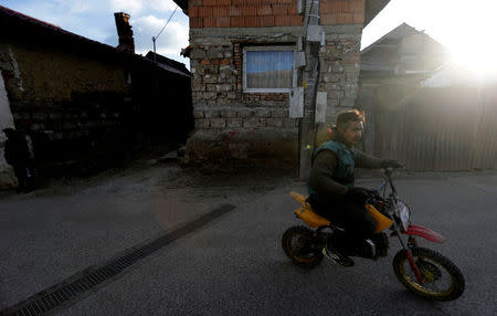 A Roma man rides his bike past a refurbished house near the so called "Sheffield Square" in the town of Bystrany, Slovakia, November 28, 2016. REUTERS/David W Cerny