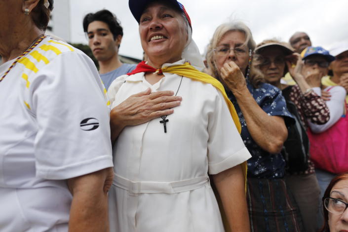 A religious woman joins a protest against the government of President Nicolas Maduro, as National Assembly President Juan Guaido visits points of protest in different areas of Caracas, Venezuela, Tuesday, March 12, 2019. Guaido has declared himself interim president and demands new elections, arguing that President Nicolas Maduro's re-election last year was invalid. (AP Photo/Ariana Cubillos)