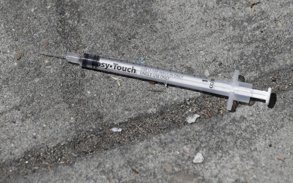 In this file photo from Thursday, May 10, 2018, a used syringe is shown on a sidewalk in San Francisco. A center for people experiencing methamphetamine-induced psychosis will open in San Francisco as the city struggles with a rise in drug overdoses and rampant street drug use. The San Francisco Chronicle reports the center will open in late spring. (AP Photo/Jeff Chiu)