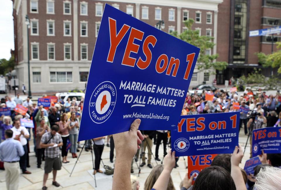 FILE - In this Sept. 10, 2012, file photo, gay marriage supporters gather at a rally outside of City Hall in Portland, Maine, in support of an upcoming ballot question that seeks to legalize same-sex marriage. After all the economy-focused campaign talk, voters in some states will get a chance on Election Day to sound off on intriguing topics that the presidential rivals ignored, including gay marriage, death-penalty repeal, marijuana legalization and assisted suicide. (AP Photo/Joel Page, File)