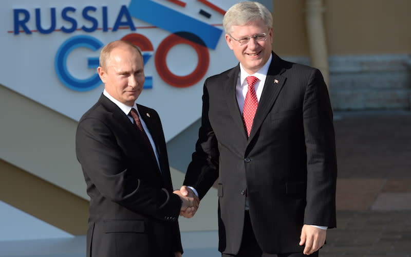 This photo shows Russian President Vladimir Putin, left, and former Canadian prime minister Stephen Harper shaking hands at the G20 summit in St. Petersburg, Russia, in September 2013. Fourteen months after this handshake, Harper reportedly told Putin to “get out of Ukraine.” Photo from Getty Images.