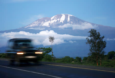 FILE PHOTO: A vehicle drives past Mount Kilimanjaro in Tanzania's Hie district December 10, 2009. REUTERS/Katrina Manson