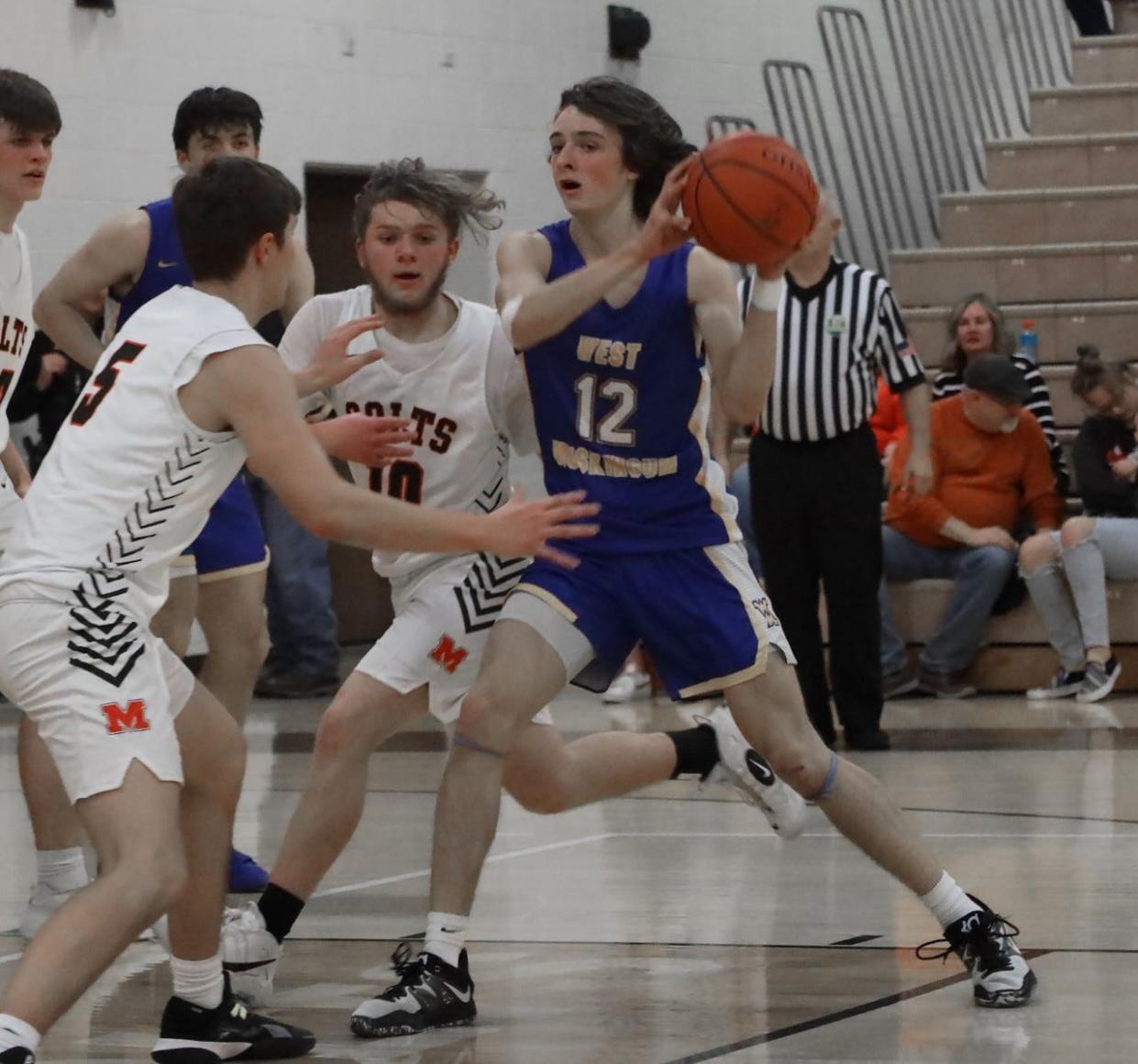 West Muskingum sophomore Jacob Anton (12) looks for a teammate with Meadowbrook defenders Colton Delancey (5) and Justice Huey (10) applying pressure during Tuesday's MVL Small School battle in Byesville.