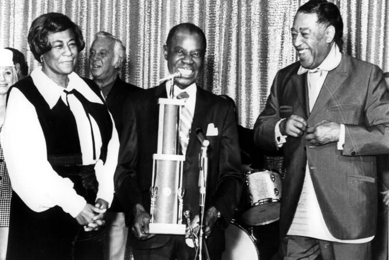 A number of the greatest jazz musicians in the world gather in 1971 at the Tropicana Hotel in Las Vegas to pay tribute to the "grandaddy" of jazz, Louis "Satchmo" Armstrong, who received a trophy topped by a silver trumpet mouthpiece from two other all-time greats, Ella Fitzgerald (L) and Duke Ellington (R). File photo UPI