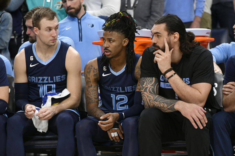 Memphis Grizzlies guard Ja Morant (12) sits between guard Luke Kennard (10) and center Steven Adams during Game 1 of a first-round NBA basketball playoff series against the Los Angeles Lakers, Sunday, April 16, 2023, in Memphis, Tenn. (AP Photo/Brandon Dill)