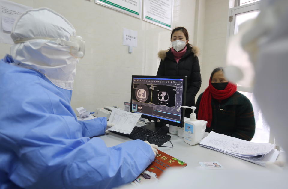 A doctor reads the computed tomography (CT) scans of a woman's lungs in a fever clinic in Yinan County, in east China's Shandong province, 12 February 2020.