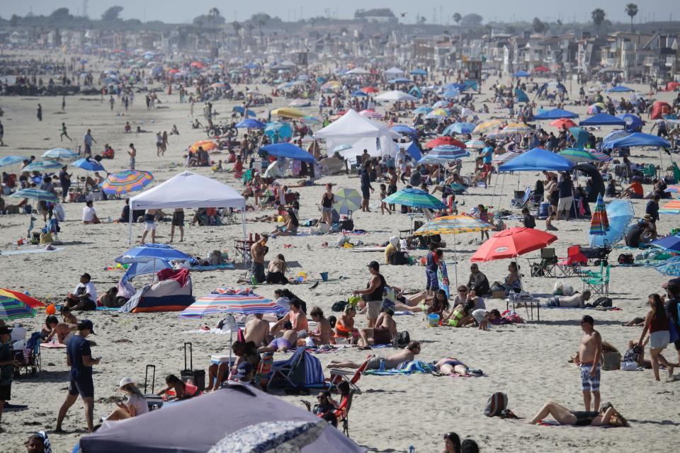 Visitors gather on the beach Sunday, May 24, 2020, in Newport Beach, Calif., during the coronavirus outbreak.