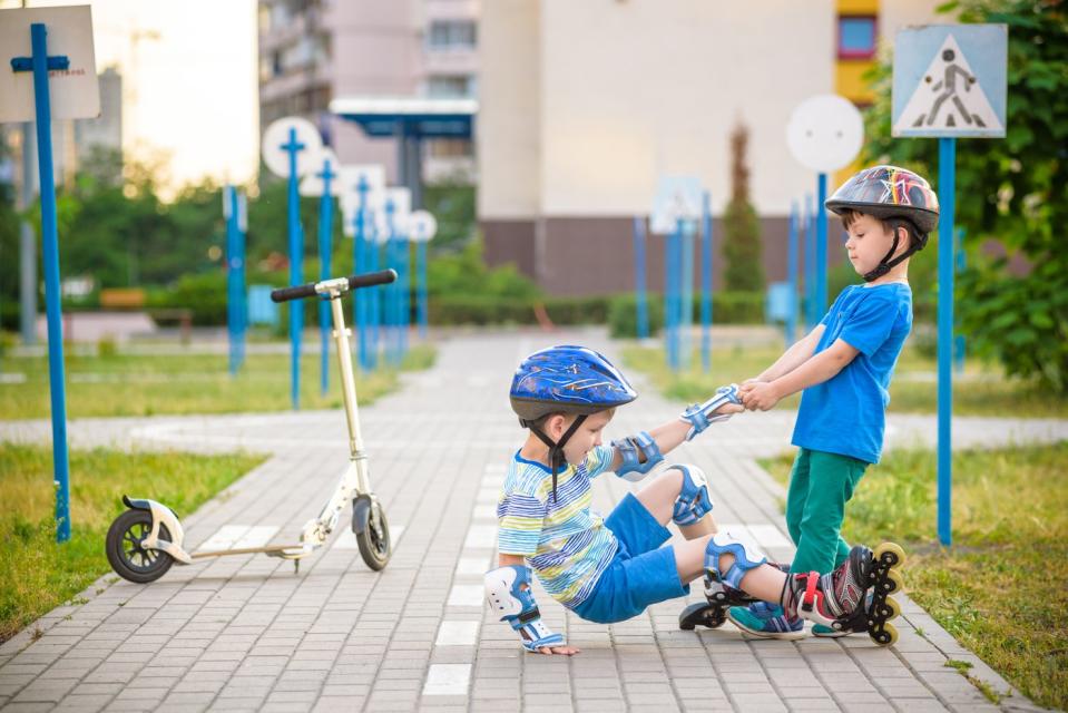 Two kids playing on roller skates.