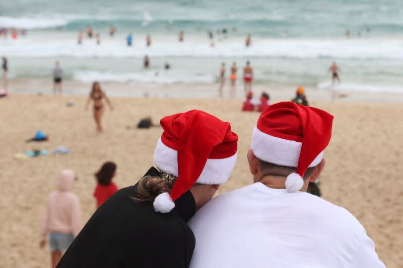 People wear Santa hats on Christmas Day at Bondi Beach in Sydney