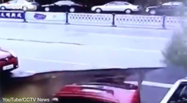 The moment the earth opened up, swallowing up the cars. Source: YouTube/CCTVNews.