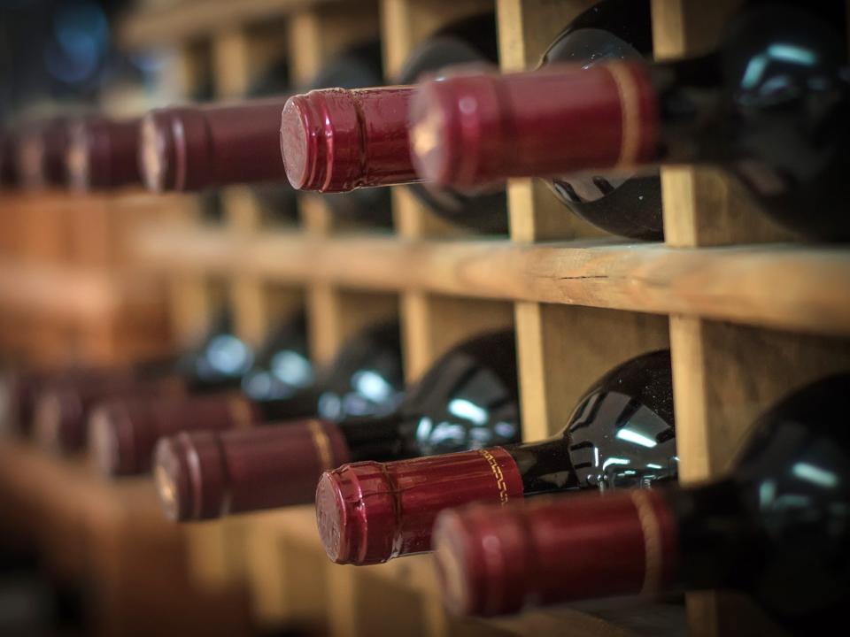 bottle of the same red wine stacked on wooden shelves