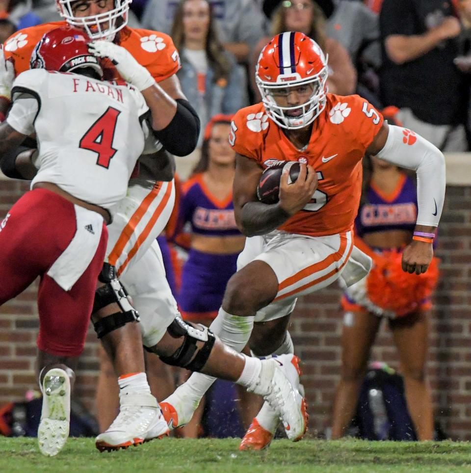 Clemson quarterback DJ Uiagalelei (5) runs near NC State defensive back Cecil Powell (4) during the first quarter at Memorial Stadium in Clemson, South Carolina, Oct. 1, 2022.